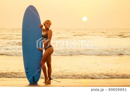 african american surfer girl in water enjoying sunset 89609891