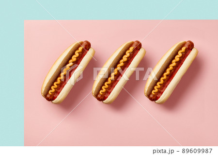 Classic hot dog with wurst, ketchup and mustard on pink table. Menu for cafe and restaurant Classic hot dog with wurst, ketchup and mustard on pink table. Menu for cafe and restaurant 89609987