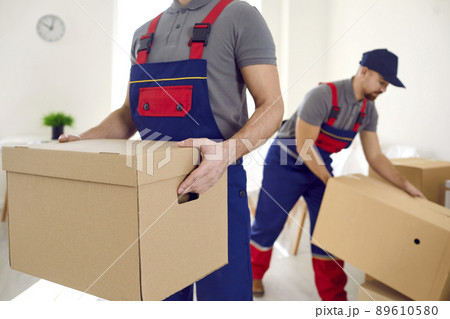 Male movers with boxes unload client belongings 89610580