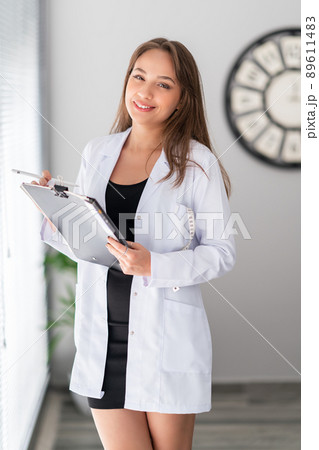 A attractive female dietician doctor is holding a notebook and looking with, confidence and pretty smile. A attractive female dietician doctor is holding a notebook and looking with, confidence and pretty smile. 89611483