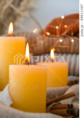 Hello Fall, celebrating autumn holidays at cozy home on the windowsill Hygge atmosphere Thanksgiving leaves, spices and candle on cozy knitted sweater in warm yellow lights. Raining Outside the window 89611497