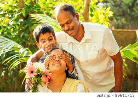 indian little boy holding bouquet and making surprise for his mother outdoor in park indian little boy holding bouquet and making surprise for his mother outdoor in park 89611715
