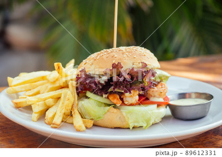 prawns burger and french fry on table tropical sea ,palms tree and beach background 89612331