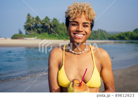 hispanic latin beautiful female drinking coco nut water seashells on the neck 89612623