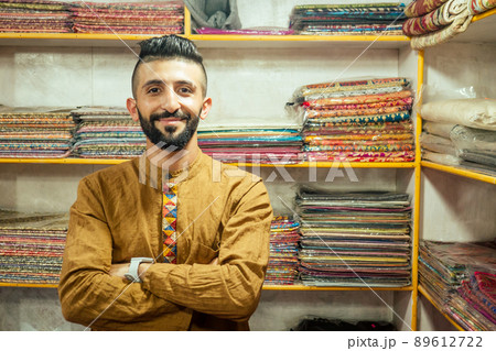 small shop owner indian man selling shawls at his store in arambol goa small shop owner indian man selling shawls at his store in arambol goa 89612722