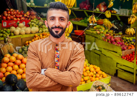 arabian man offering a pineapple on the street in goa 89612747