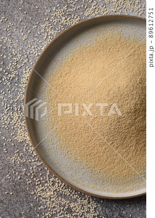 Sesame flour in plate for cooking vegan gluten-free dessert. Sesame flour in plate for cooking vegan gluten-free dessert. 89612751