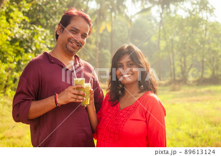 happy indian family holding glass of fresh cane juice with eco metal tube. Love to health and save planet . recyclable concept 89613124