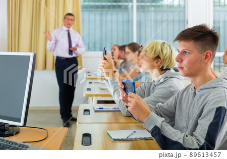 Side view of student group working with mobile phones in class 89613457