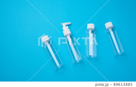 Various transparent empty plastic bottles and jars for cosmetics on a blue background, top view Various transparent empty plastic bottles and jars for cosmetics on a blue background, top view 89613885