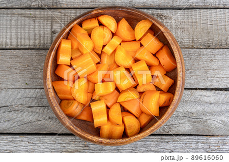 Chopped carrots in bowl on wooden table. Healthy diet, vitamin salad for vegetarian. Simple food made from fresh ingredients 89616060