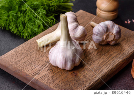Heads of fresh white garlic on a wooden cutting board 89616446