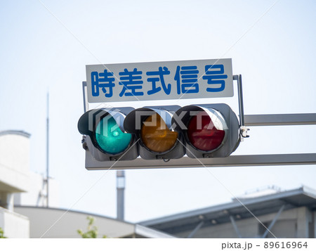 青色が点灯している、「時差式信号」表示板付きの信号機。 青色が点灯している、「時差式信号」表示板付きの信号機。 89616964