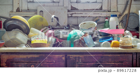 Pile of dirty utensils in a kitchen washbasin Pile of dirty utensils in a kitchen washbasin 89617228