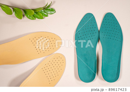 Orthopedic insoles are lined up on a wooden surface. samples of different orthopedic insoles. insoles with a variety of coating. Orthopedic insoles are lined up on a wooden surface. samples of different orthopedic insoles. insoles with a variety of coating. 89617423