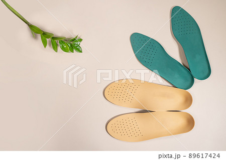 Orthopedic insoles are lined up on a wooden surface. samples of different orthopedic insoles. insoles with a variety of coating. Orthopedic insoles are lined up on a wooden surface. samples of different orthopedic insoles. insoles with a variety of coating. 89617424