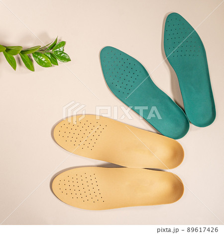 Orthopedic insoles are lined up on a wooden surface. samples of different orthopedic insoles. insoles with a variety of coating. Orthopedic insoles are lined up on a wooden surface. samples of different orthopedic insoles. insoles with a variety of coating. 89617426