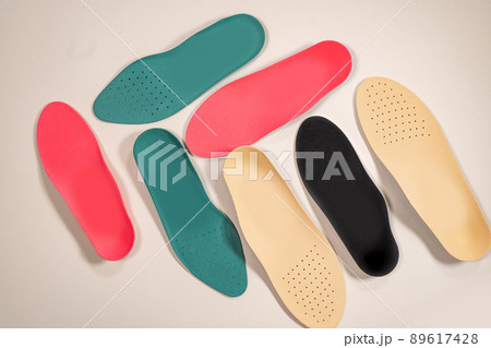 Orthopedic insoles for shoes on a colour background. Foot care 89617428