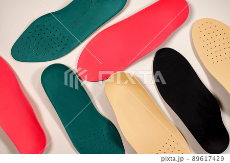 Orthopedic insoles are lined up on a wooden surface. samples of different orthopedic insoles. insoles with a variety of coating. Orthopedic insoles are lined up on a wooden surface. samples of different orthopedic insoles. insoles with a variety of coating. 89617429