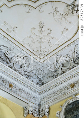 Round antique vintage decorative clay stucco relief molding with floral ornaments on white ceiling in abstract classical style interior 89617439