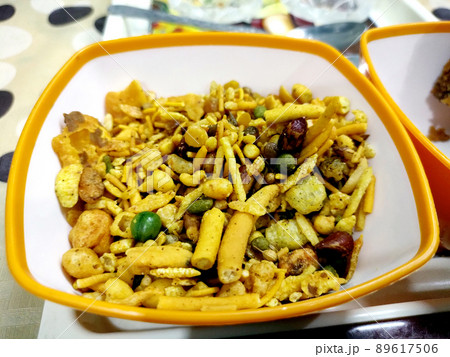 Close up of plane salty Golden Mixture Indian namkeen (snacks) on a ceramic black bowl. Top view 89617506