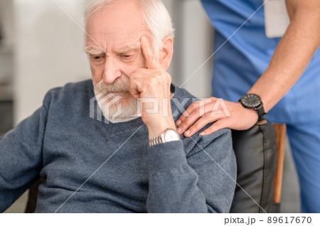 Low-spirited elderly person comforted by his caregiver Low-spirited elderly person comforted by his caregiver 89617670