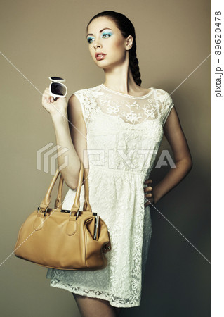 Portrait of beautiful young woman with a leather bag 89620478