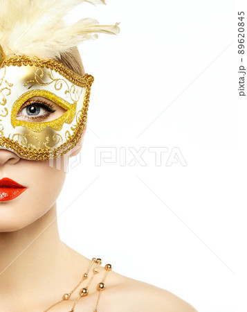 Beautiful young woman in mysterious golden Venetian mask Beautiful young woman in mysterious golden Venetian mask 89620845