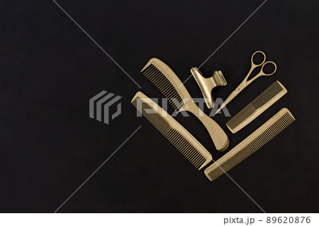 Hairdressing tools in black and gold on concrete background. Hair salon accessories, combs, scissors and hair clips with copy space. Template for business cards Hairdressing tools in black and gold on concrete background. Hair salon accessories, combs, scissors and hair clips with copy space. Template for business cards 89620876