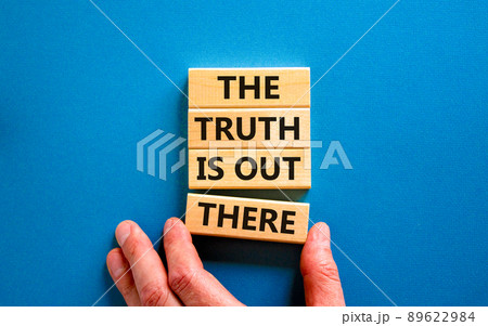 The truth is out there symbol. Concept words The truth is out there on wooden blocks. Businessman hand. Beautiful blue table blue background. The truth is out there business concept. Copy space. 89622984