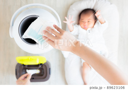 おむつ用ゴミ箱に捨てる母親の手元 89623106