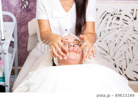 Cosmetology. A cosmetologist makes the client a massage procedure. Copy space. Concept of professional care in beauty salons Cosmetology. A cosmetologist makes the client a massage procedure. Copy space. Concept of professional care in beauty salons 89623289