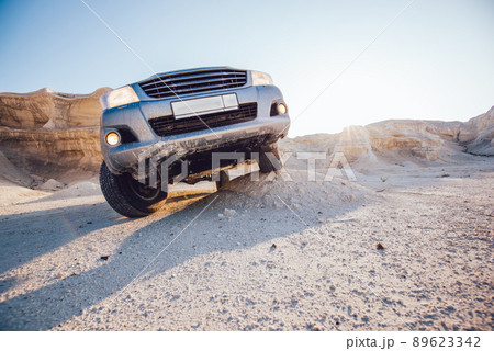 Crossover automobile parked in sunny desert 89623342