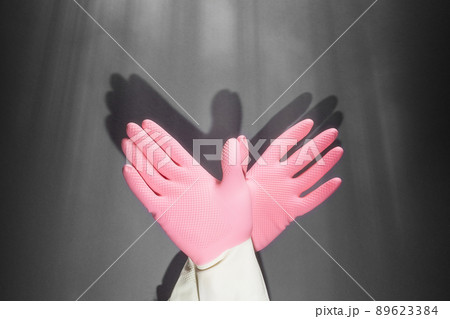Shadow theater. Hands in rubber gloves shows the figure of a pigeon. On the dark wall, the shadow of the hands in the form of a bird Shadow theater. Hands in rubber gloves shows the figure of a pigeon. On the dark wall, the shadow of the hands in the form of a bird 89623384