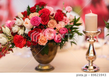Bouquet of flowers in vase and candle on the wedding table 89623943