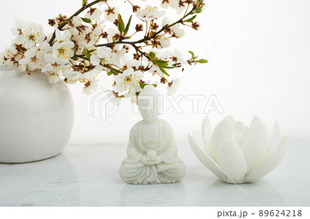 Vesak, Wesak, Buddha birthday. Buddha statue with blossoming cherry on white background. Spa ritual. Mental health and meditation. 89624218