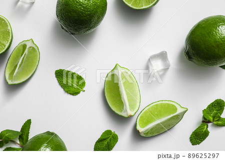 Flat lay composition with fresh juicy limes, mint and ice cubes on white background Flat lay composition with fresh juicy limes, mint and ice cubes on white background 89625297