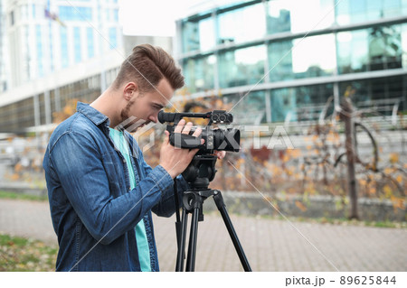 Video operator with camera working on city street 89625844