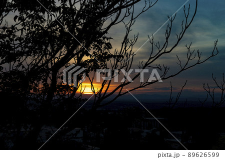 Sunset. Sunset with high clouds leaving the sky orange and blue. Backlight of the leaves and branches of the trees in a park in Madrid, in Spain. Europe. Horizontal photography. Sunset. Sunset with high clouds leaving the sky orange and blue. Backlight of the leaves and branches of the trees in a park in Madrid, in Spain. Europe. Horizontal photography. 89626599