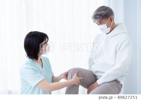 ミドル男性の足の症状を確認する女性看護師 89627251