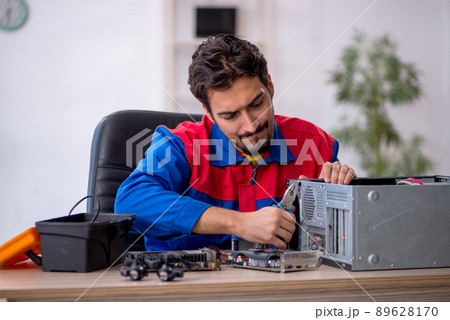 Young male repairman repairing computer 89628170