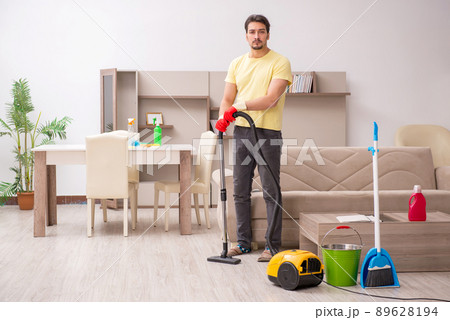 Young male contractor cleaning the house Young male contractor cleaning the house 89628194