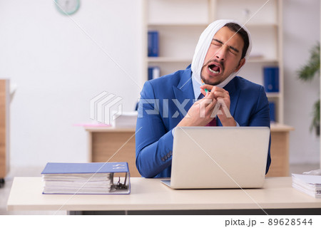 Young male employee suffering from toothache at workplace 89628544