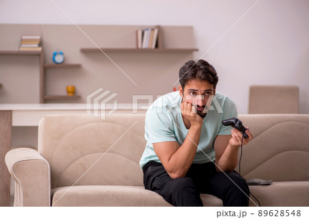Young man playing joystick games at home 89628548