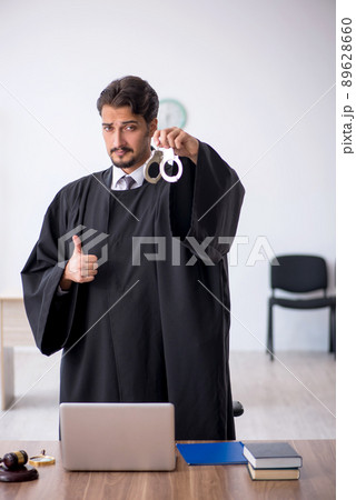 Young male judge working in the courthouse Young male judge working in the courthouse 89628660