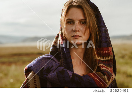 close-up. In the steppe stands a girl without makeup with natural beauty in an ethno cape with strictly looking into the distance close-up. In the steppe stands a girl without makeup with natural beauty in an ethno cape with strictly looking into the distance 89629491
