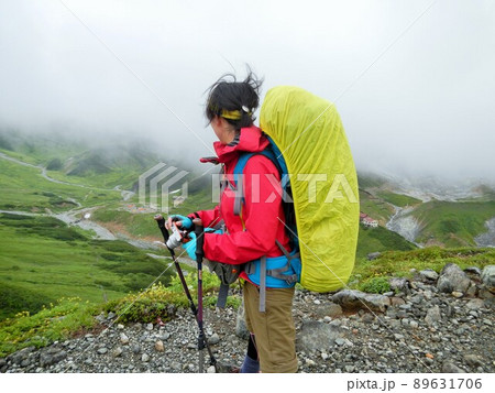 風の強い中の登山者と視界の開けた風景 風の強い中の登山者と視界の開けた風景 89631706