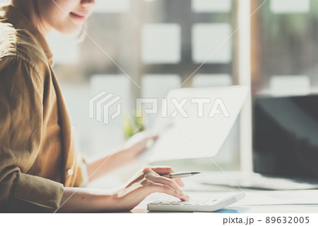 Close up Business woman hand using calculator to calculate the company's financial results and budget. Account Audit Concept.. Close up Business woman hand using calculator to calculate the company's financial results and budget. Account Audit Concept.. 89632005