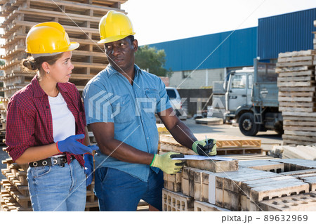 Builders talking in construction material storage 89632969