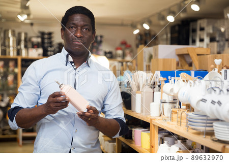 Portrait of man choosing deodorant in dishware store 89632970